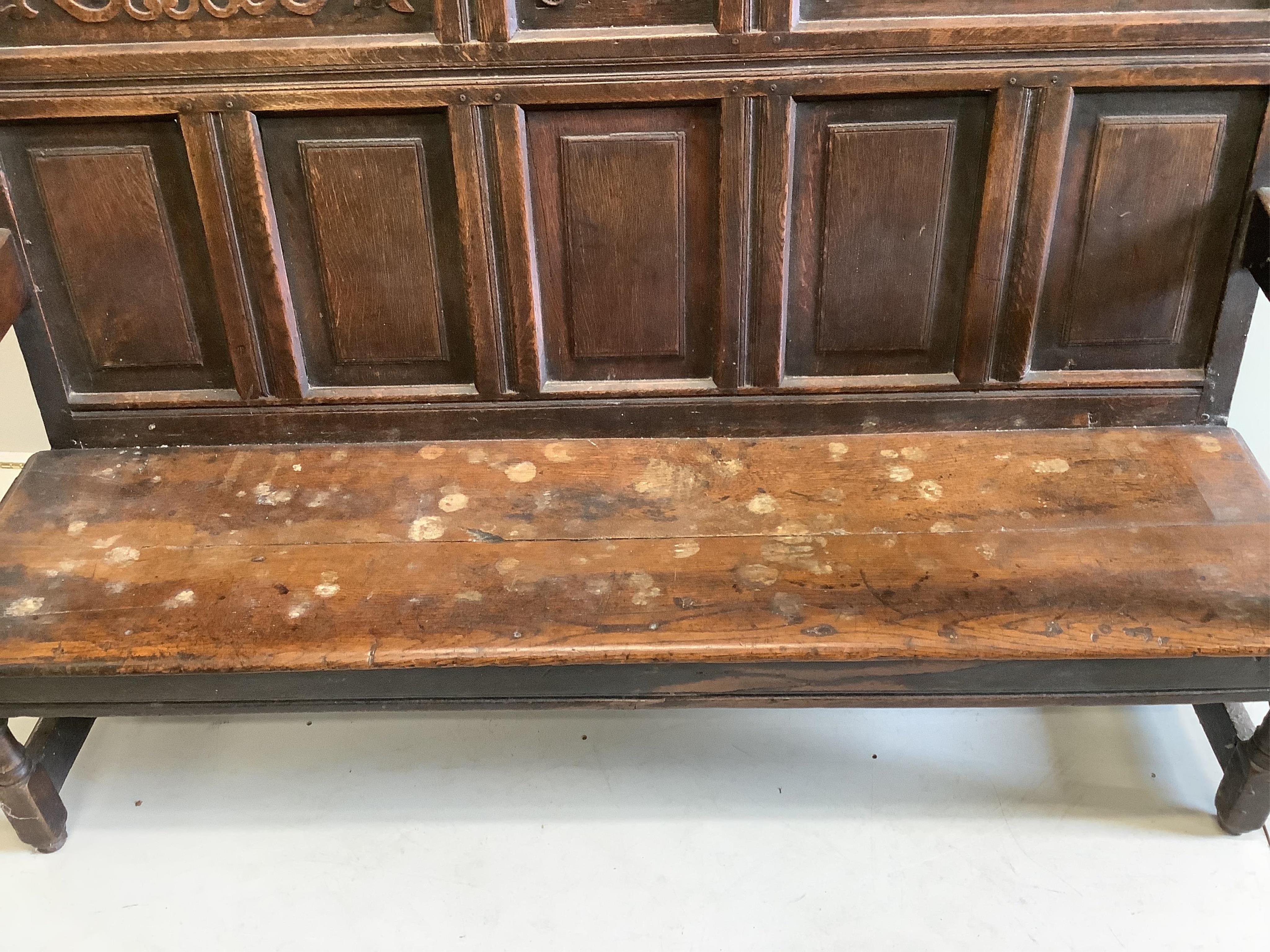 A mid 18th century carved oak settle, width 171cm, depth 58cm, height 122cm. Condition - poor to fair